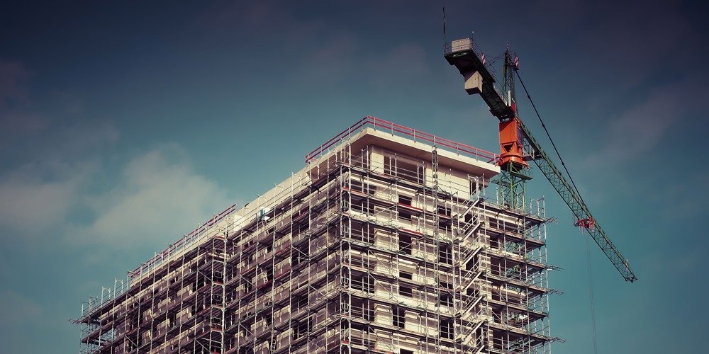 Edificio en construcción con andamios y grúa